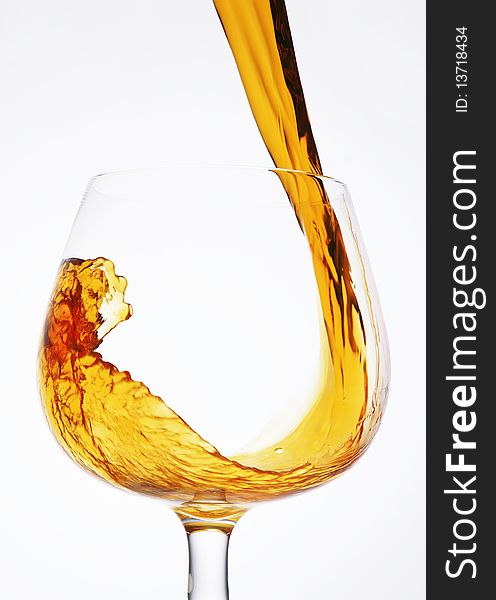 Pour a glass of cognac on a white background