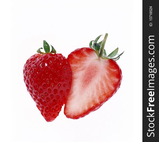 Strawberries cut in half on a white background.