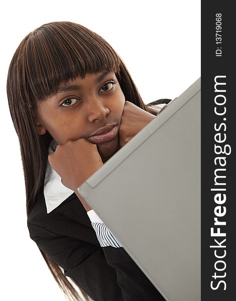 Young black female executive with face in hands behind laptop