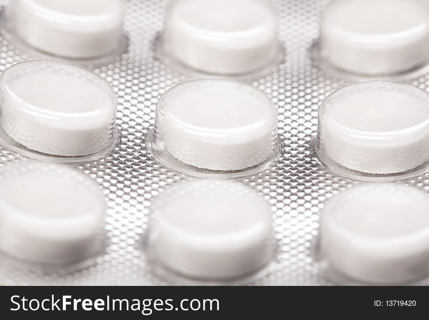 Macro shot of white pills` set isolated on white backround