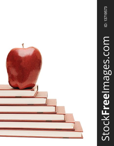 Stack of books and apple isolated over white