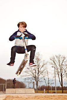 Young Boy Jumps With Scooter Over A Ramp At The Sk Royalty Free Stock Photo Young Boy Jumps With Scooter Over A Ramp At The Sk Royalty Free Stock Photo