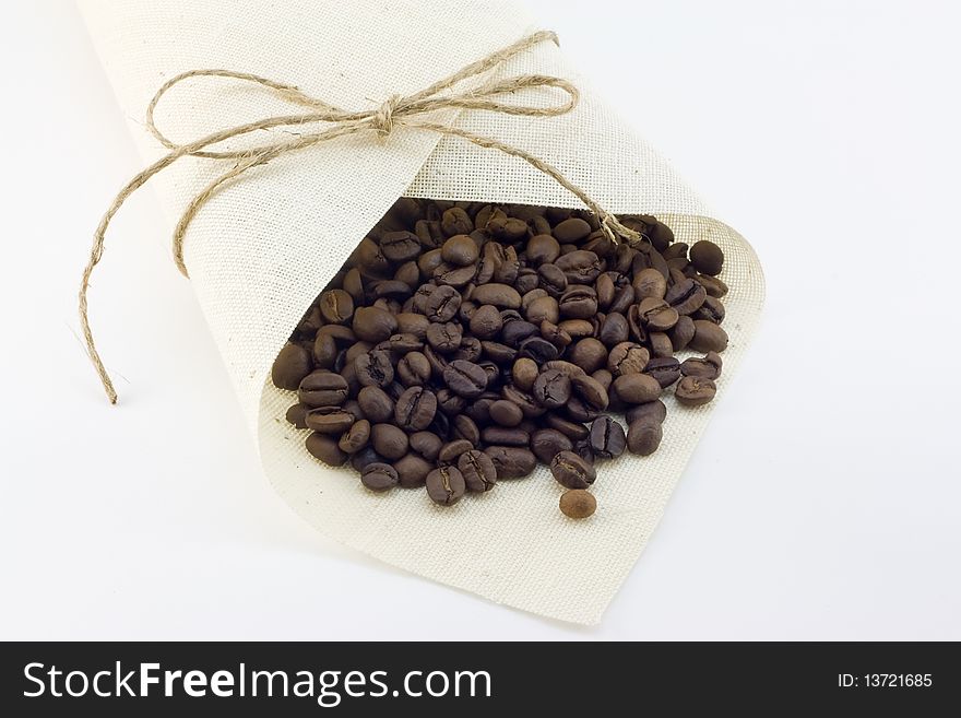 Sack tied up by a thread with coffee grains on a white background. Sack tied up by a thread with coffee grains on a white background