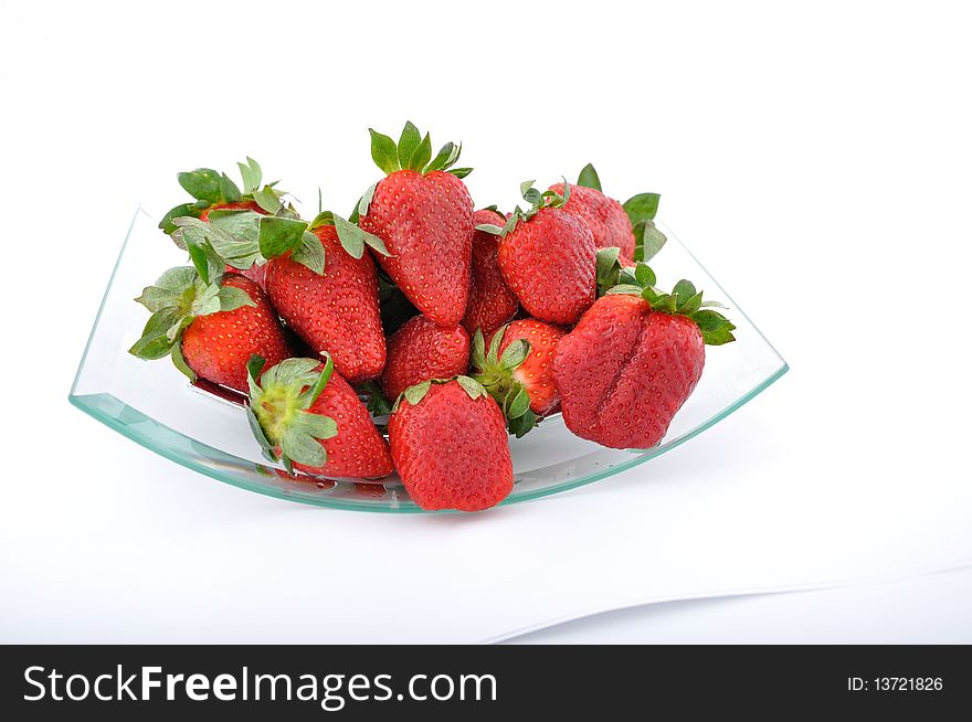 Fresh red strawberries in glass bowl on white background