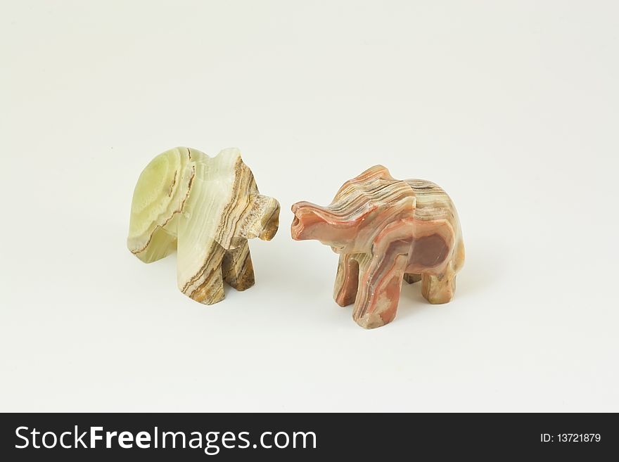 Two figures of elephants from onyx on a white background. Two figures of elephants from onyx on a white background