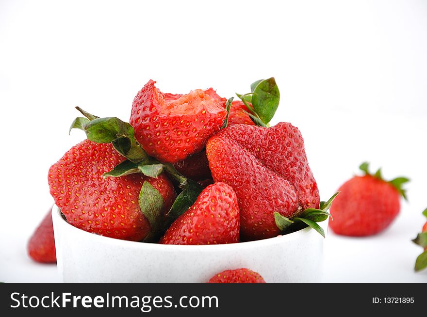 Strawberries in bowl and one with bite