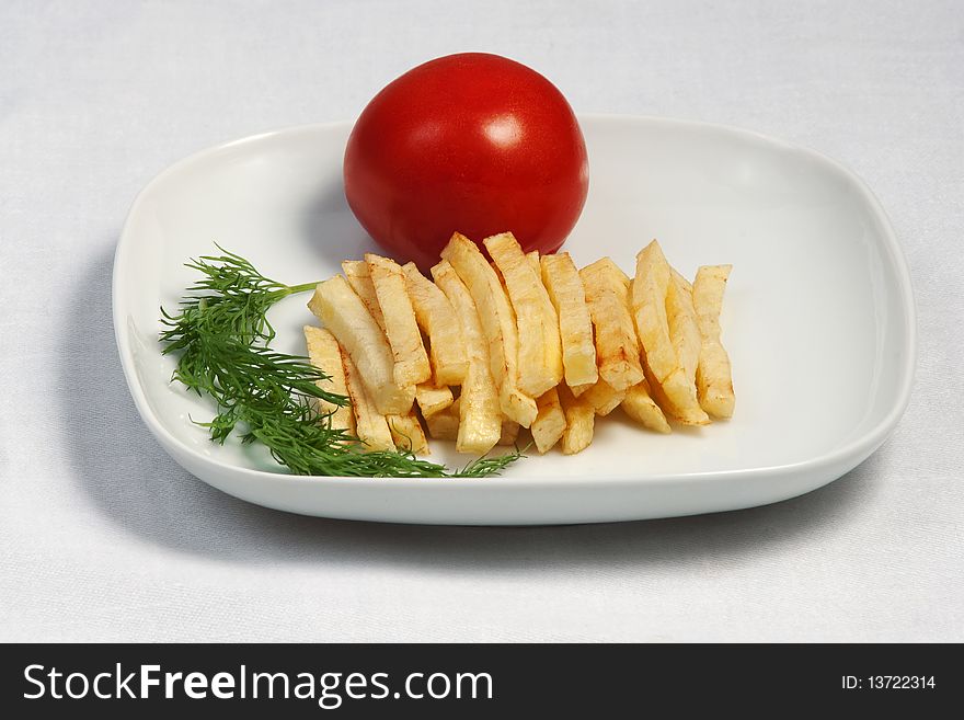 Fried potato with a tomato on a plate