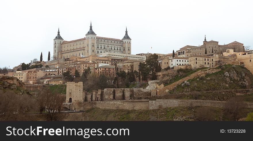 View over the rooftops of houses in Toledo Spain with fortress on a mountain top