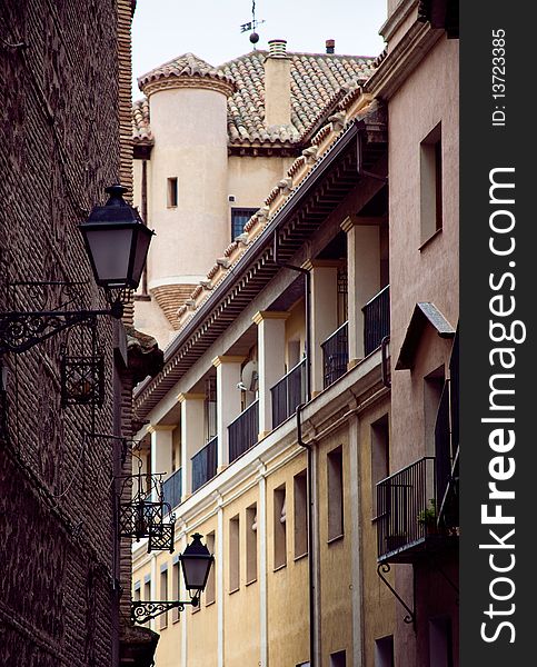 Narrow street in Toledo Spain in the summer with a lantern and windows