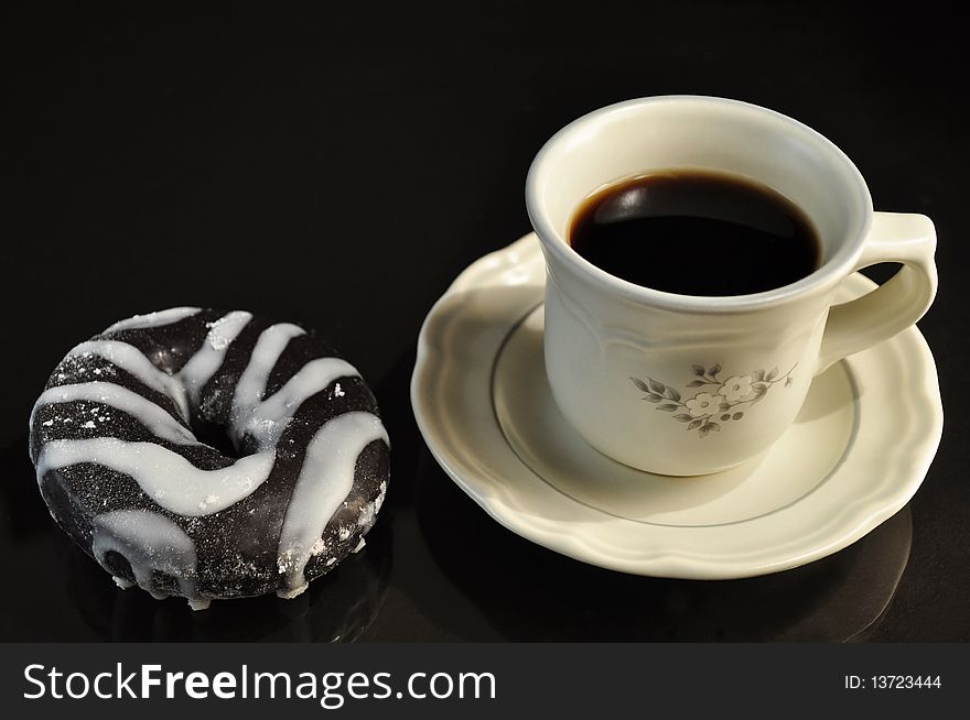 Cap of coffee with donut on black background. Cap of coffee with donut on black background