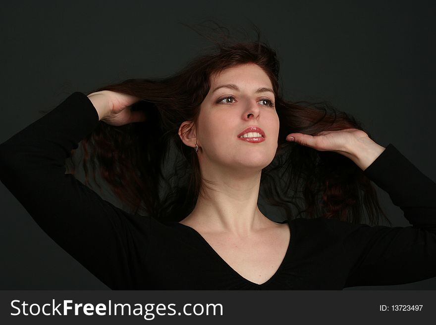 Portrait of young brunette woman isolated on black background