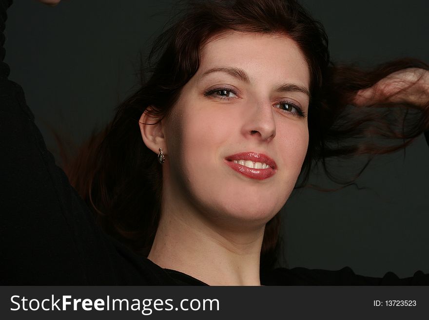 Portrait of young brunette woman isolated on black background