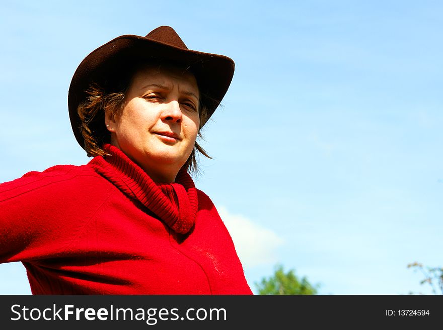 A woman in a brown hat on a background of blue sky