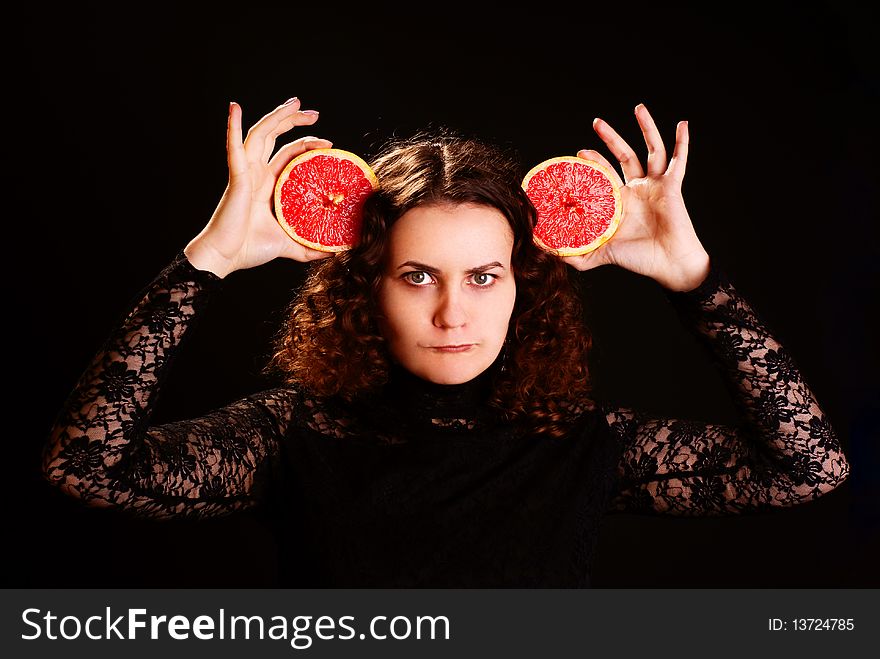 Portrait of young beautiful woman with grapefruit. Studio shot.