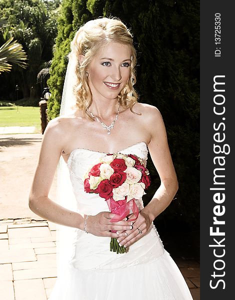 Beautiful Blond bride wearing diamond jewelery and a white gown