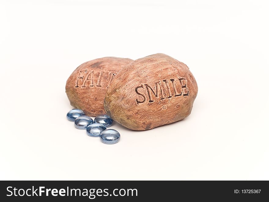 Inspirational Rocks Saying Smile and Faith with Colored Blue Stones on White.