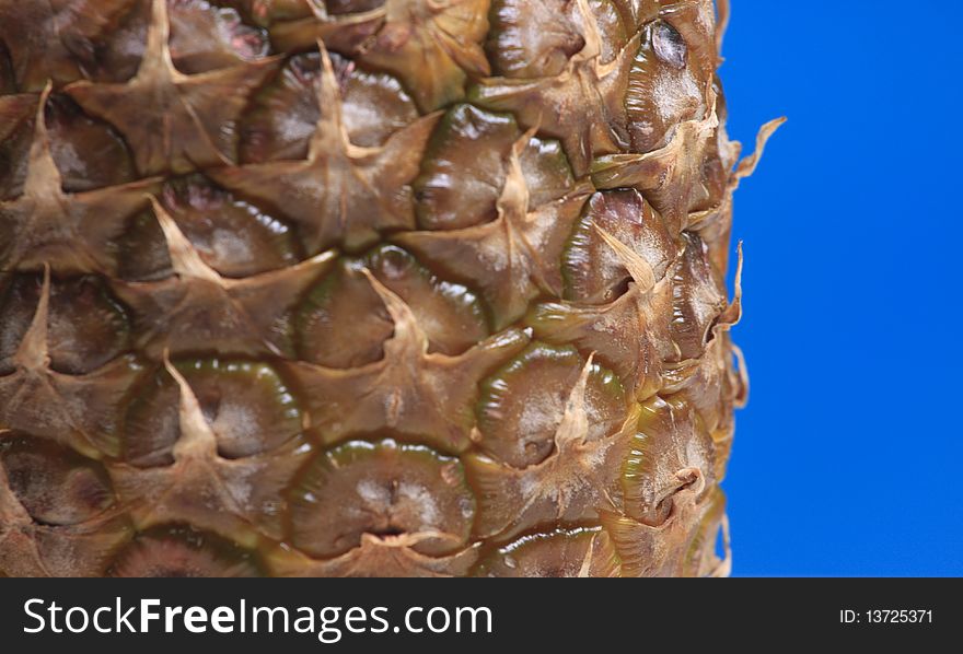 Abstract pineapple texture close up macro photo on blue. Focus on a back plane of pineapple