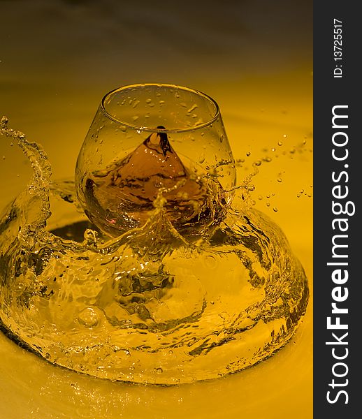 Class of brandy on creative brown background with water