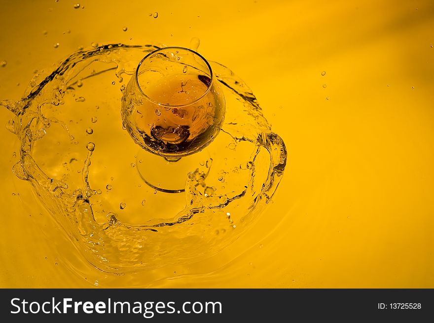 Class of brandy on creative brown background with water