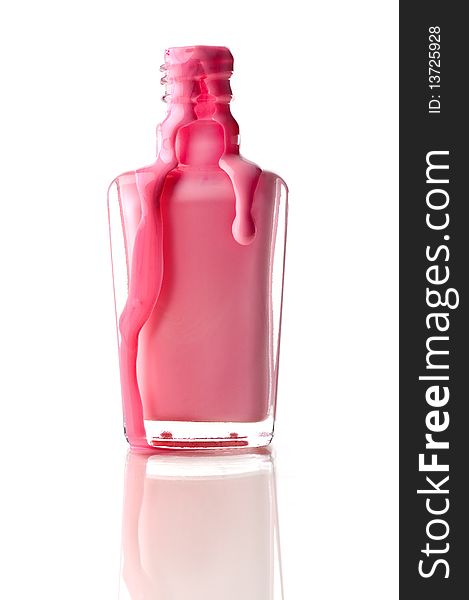 Vertical image of pink nail polish running out of a container on a reflective surface