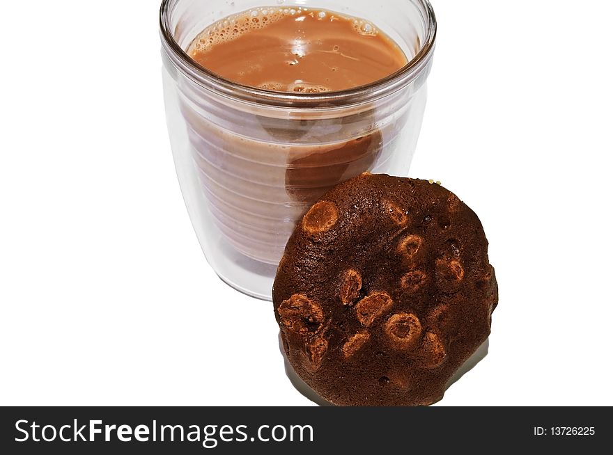 Chocolate milk in a glass with a chocolate/chocolate chip cookie beside it. Chocolate milk in a glass with a chocolate/chocolate chip cookie beside it.