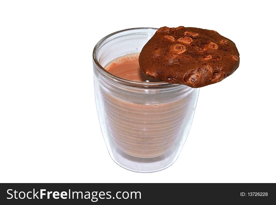 Chocolate milk in a glass with a chocolate/chocolate chip cookie on the edge. Chocolate milk in a glass with a chocolate/chocolate chip cookie on the edge.