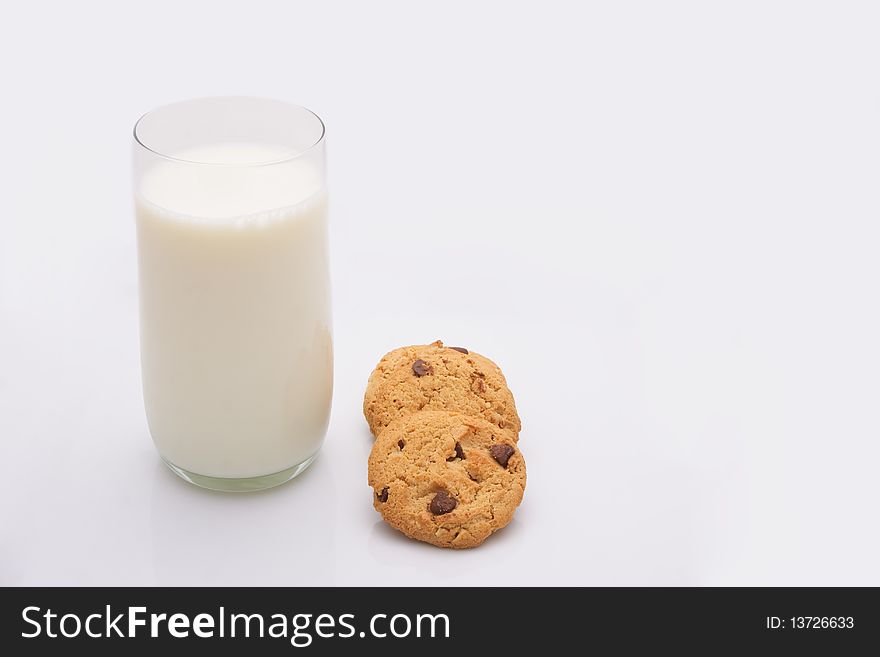 A glass of milk with choc chip cookies. A glass of milk with choc chip cookies