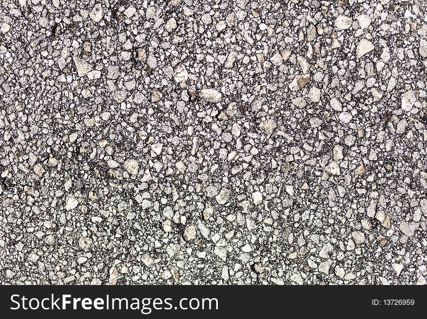 A closeup of the surface of asphalt pavement. A closeup of the surface of asphalt pavement