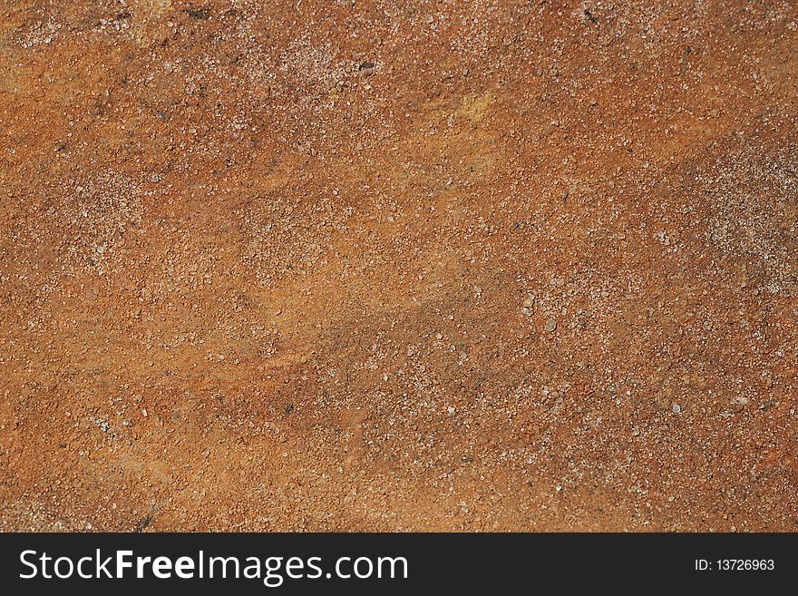 A Macro photograph of reddish hard sandy soil. A Macro photograph of reddish hard sandy soil