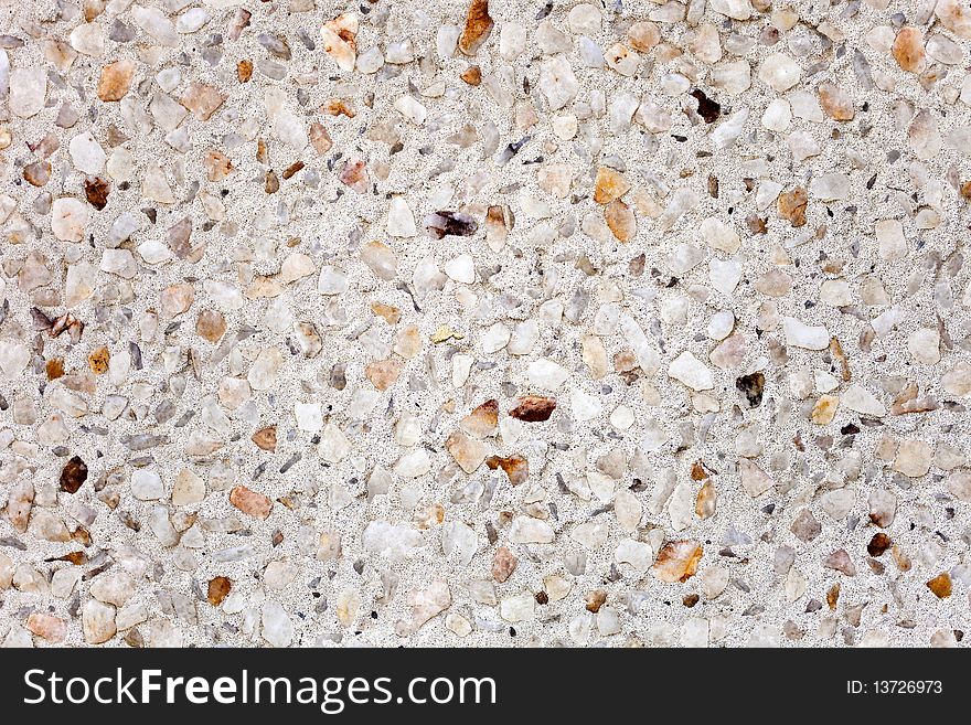 A white concrete surface with mult-colored rocks embedded into it. A white concrete surface with mult-colored rocks embedded into it.