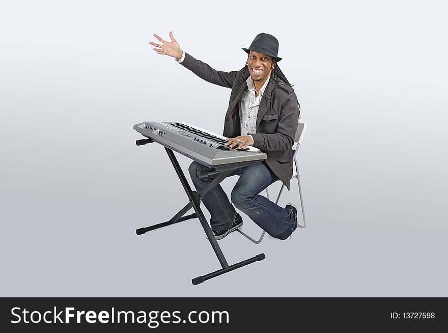 African American man seating and playing an electronic keyboard. African American man seating and playing an electronic keyboard