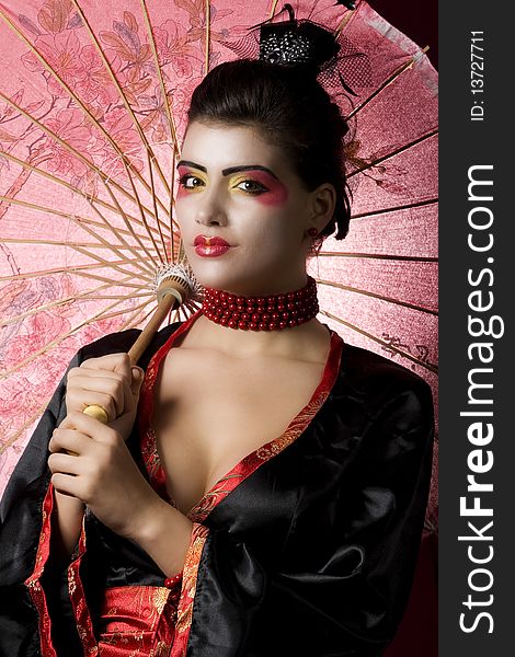 geisha holding an umbrella. studio shot. geisha holding an umbrella. studio shot