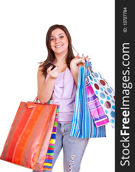 Young happy brunette girl standing holding shopping bags and cell phone. Young happy brunette girl standing holding shopping bags and cell phone