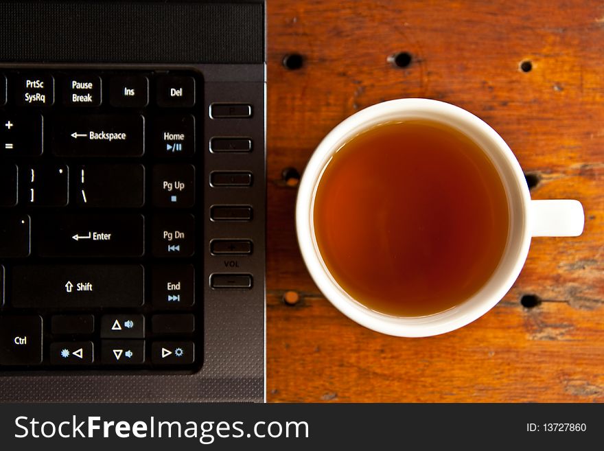 Cup of coffee and notebook keyboard. Cup of coffee and notebook keyboard