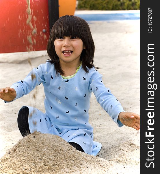 Happy girl on a playground playing with sand. Happy girl on a playground playing with sand