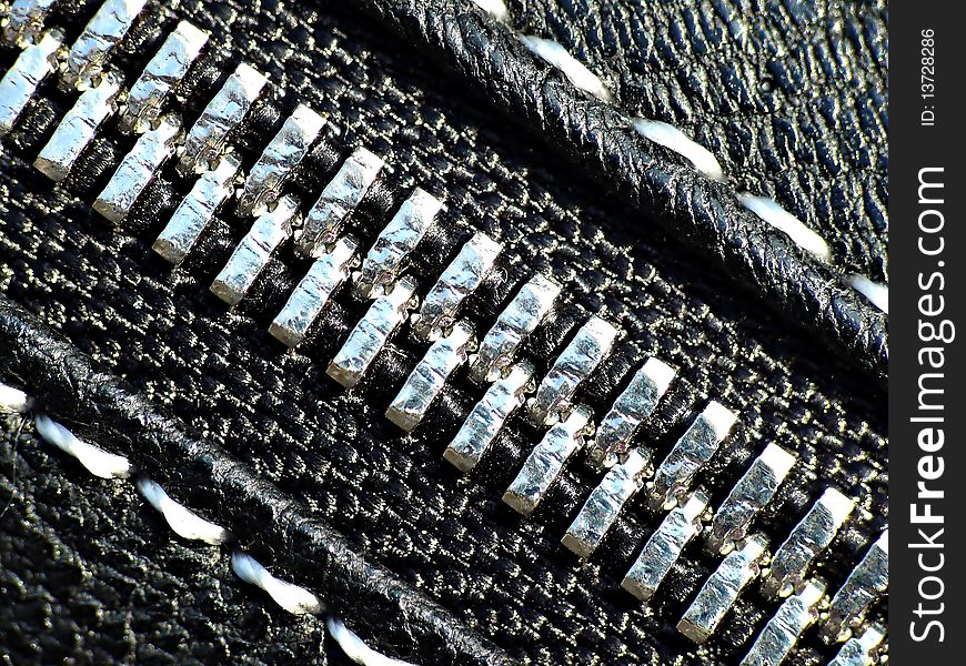 Silver zipper on black leather close-up