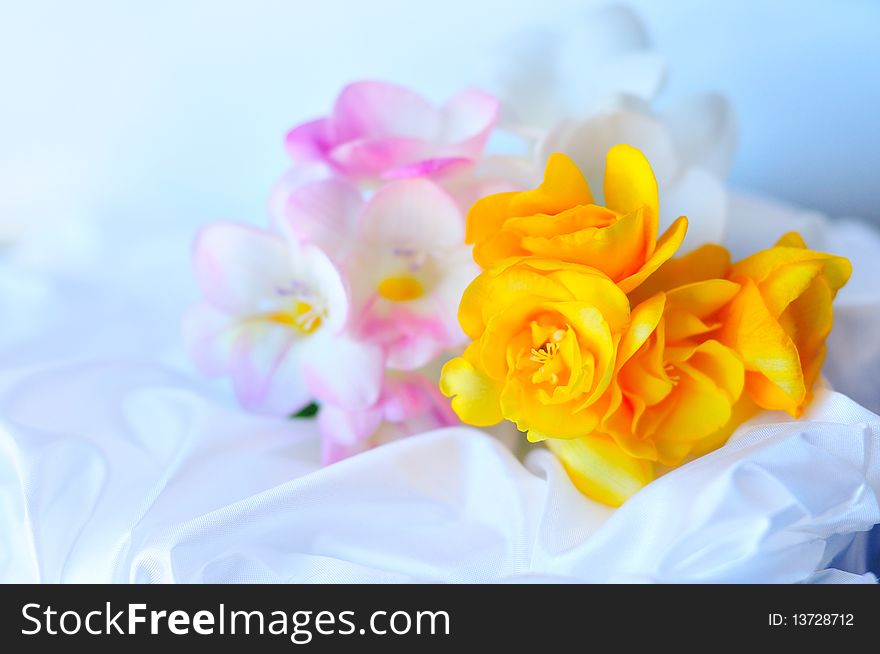 Freesias in soft focus on the wedding dress