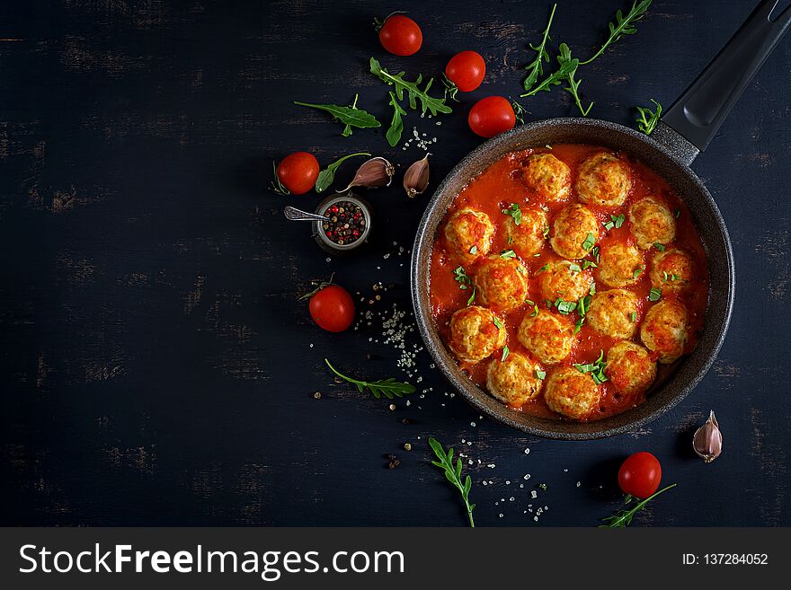 Chicken meatballs with tomato sauce in a pan. Dinner. Top view. Dark background