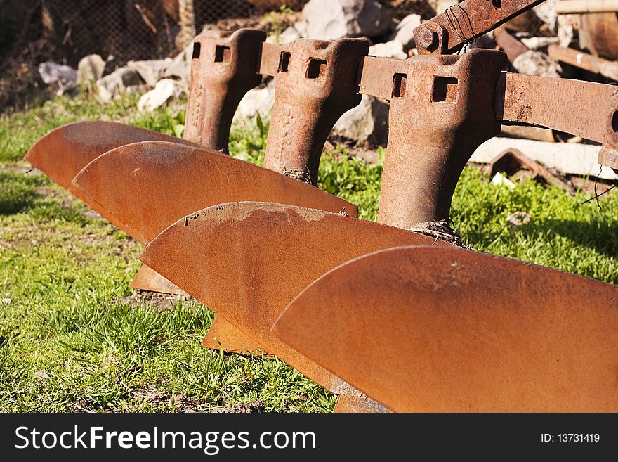 Old rusted tractor plow array