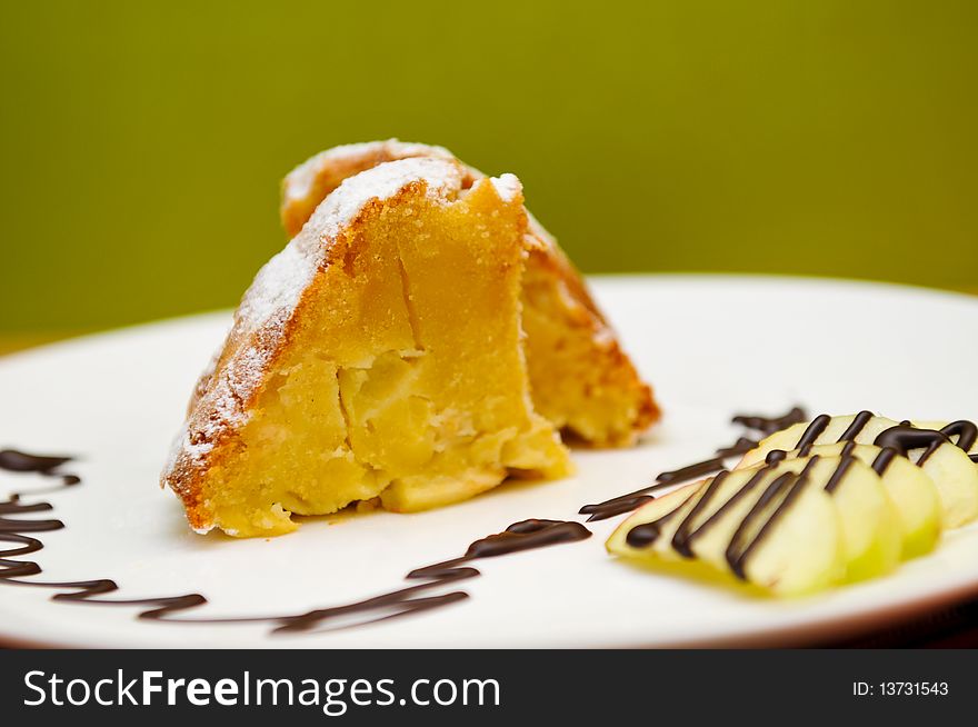 Peace of apple cake, served with apples and chocolate