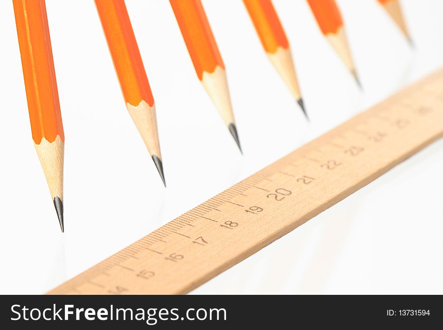 Few wooden yellow pencils in a row and ruler on white background. Few wooden yellow pencils in a row and ruler on white background