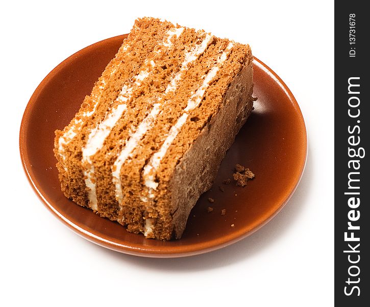 Sweet honey cake on a clay plate (isolated)