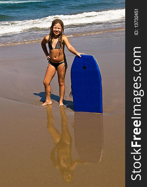 Girl Reflecting On Beach Sand With Sea In Backgrou