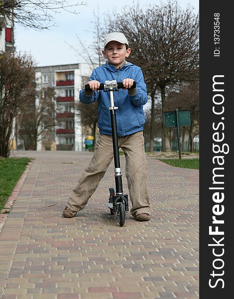 Young boy riding two wheeled scooter. Young boy riding two wheeled scooter.