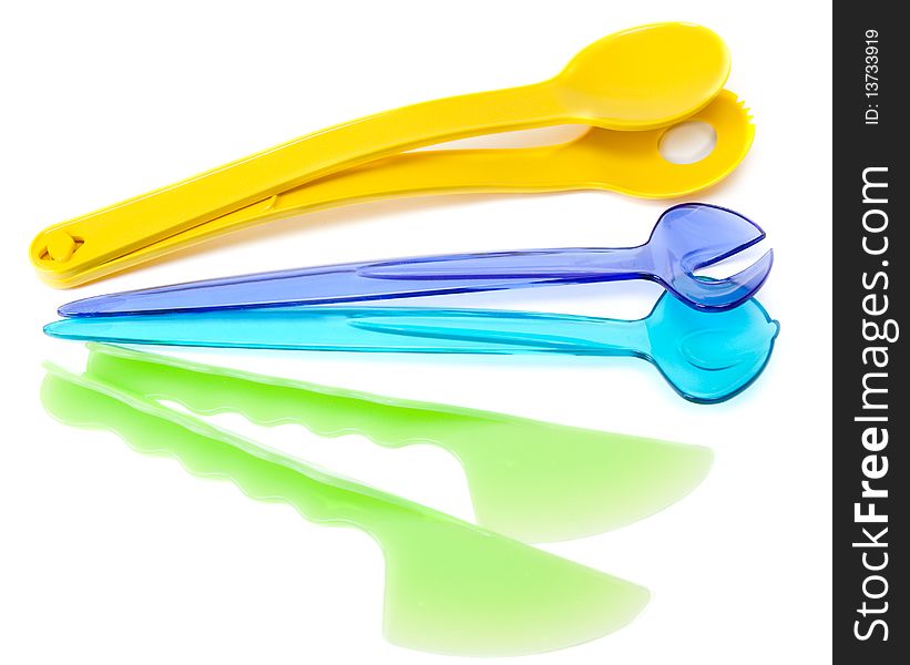 Colour plastic dishes, fork, spoon, knife on white background