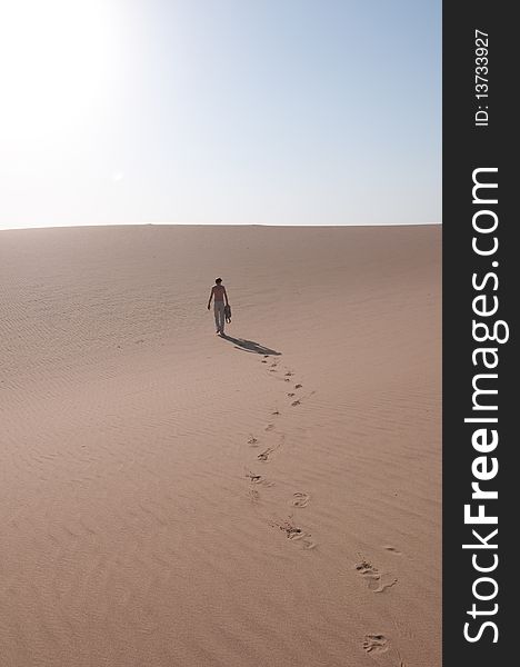 A man taking a walk in the sand dunes. A man taking a walk in the sand dunes