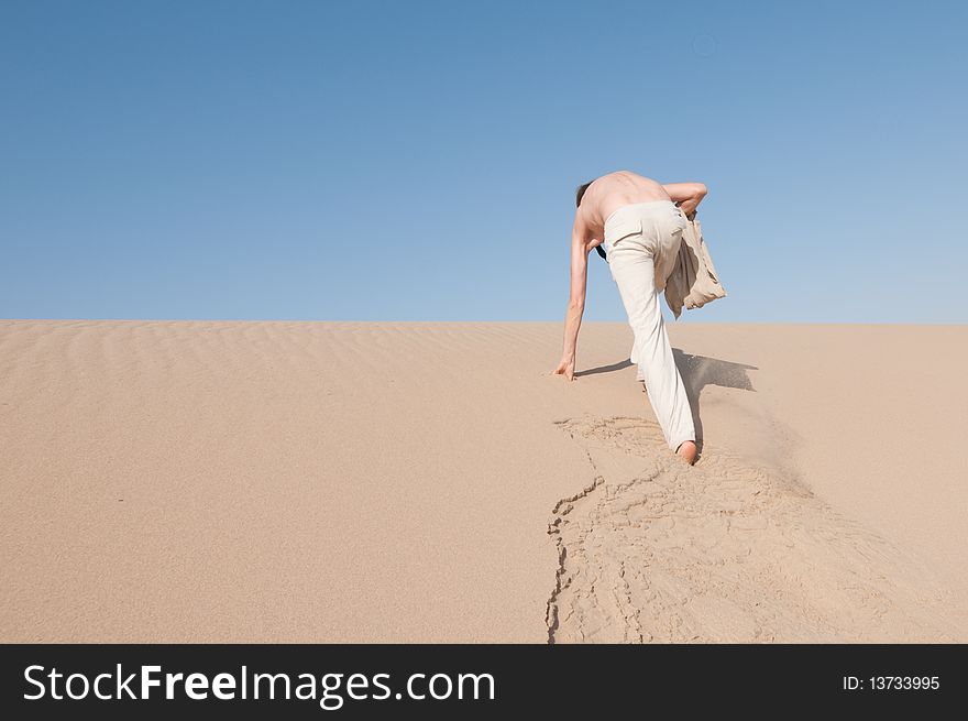 A man climbing in the sand dunes. A man climbing in the sand dunes