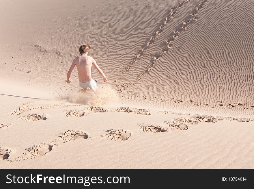 A man playing in the sand dunes. A man playing in the sand dunes