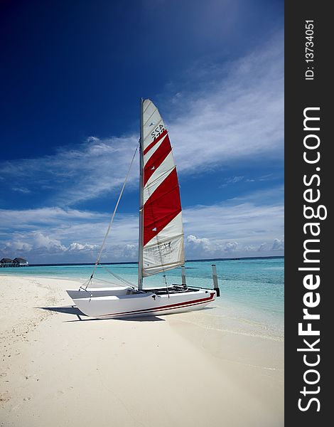 A  sail boat with colorful sail at sea. A  sail boat with colorful sail at sea.