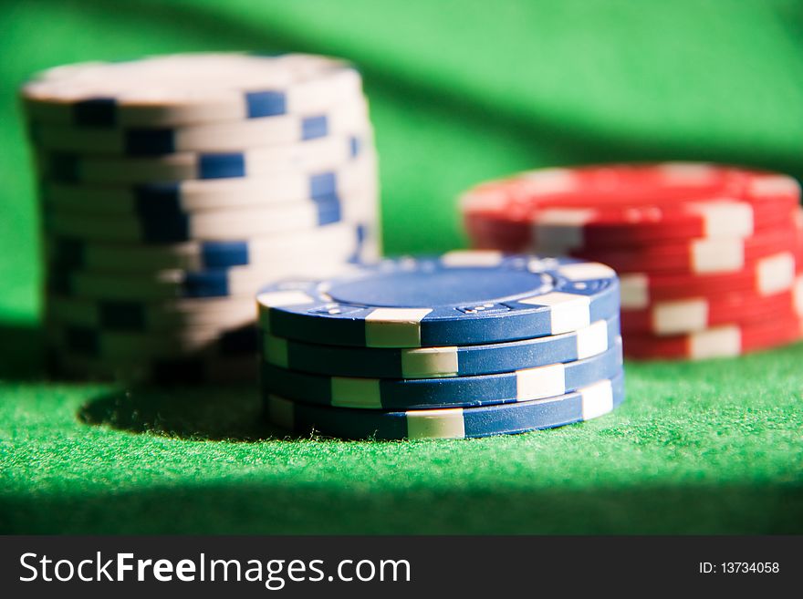 Poker chips on green on green background.